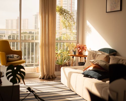A bright, comfortable living room with natural sunlight filtering through curtains